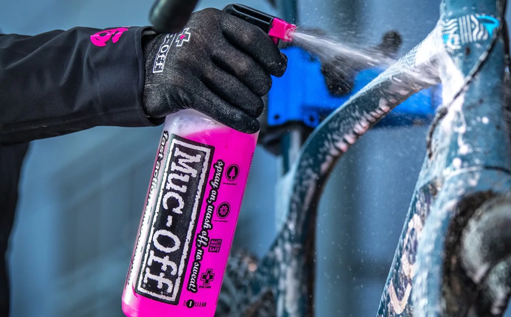Spraying the mud off a dirty bike frame.
