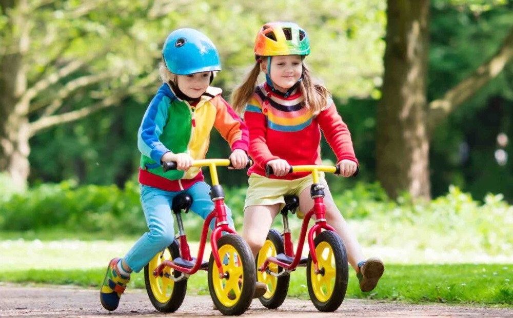 Two children riding their bikes.