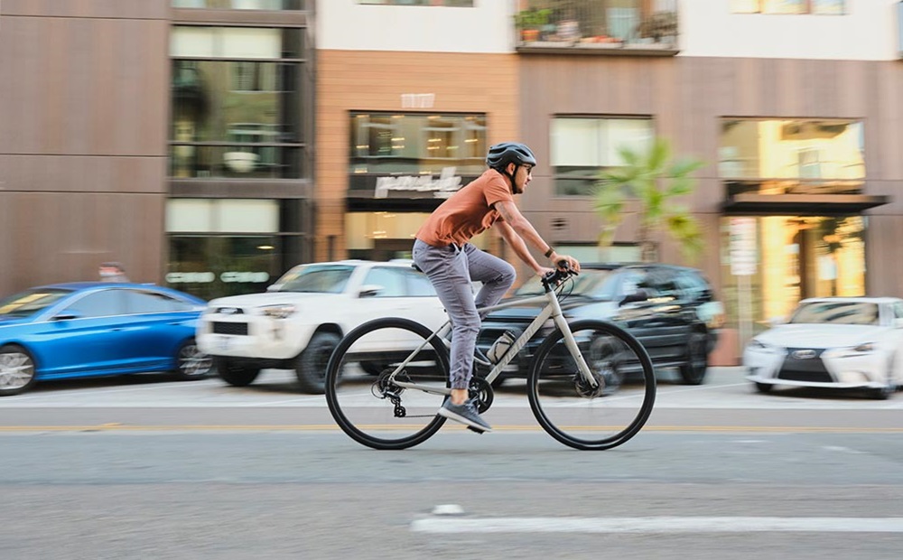 Young man enjoying commuting by bike in a city.
